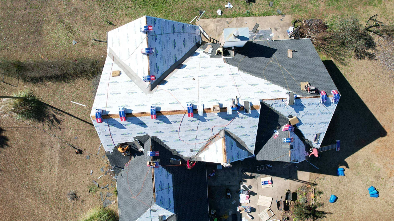 Shingle installation progressing across the featured home.